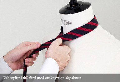 Vår stylist i full färd med att knyta en slipsknut Vår stylist i full färd med att knyta en slipsknut