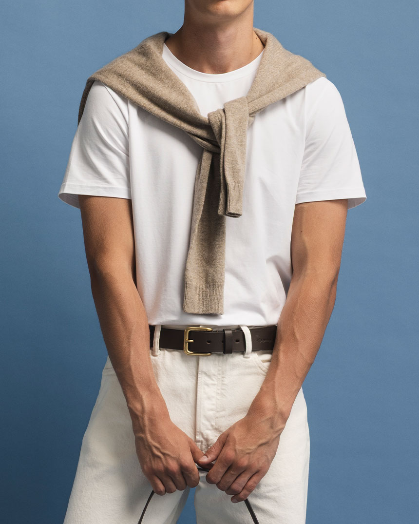 Vit T-shirt med beige tröja knuten över axlarna