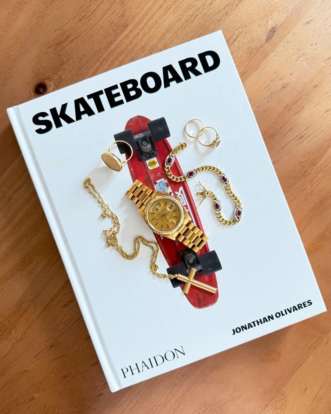 Rolex Datejust i guld och guldkedjor på en skateboardbok